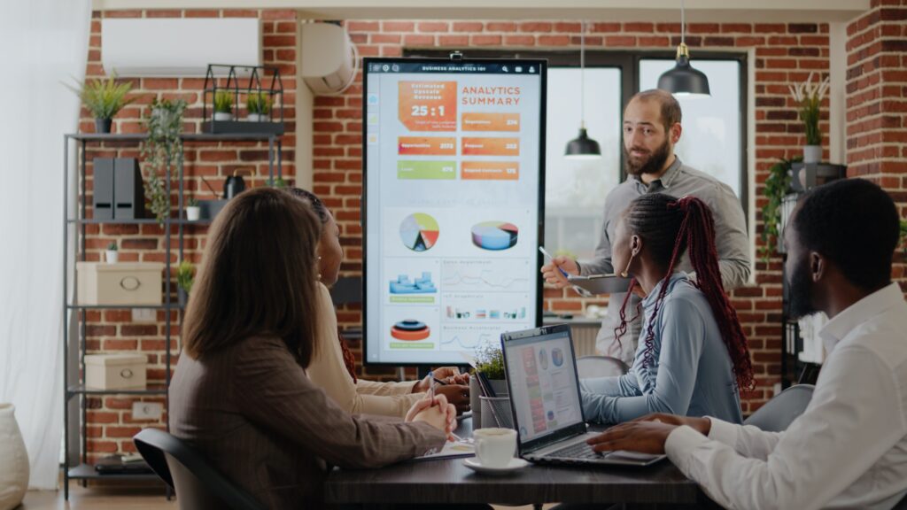 Worker talking about business growth with charts on monitor